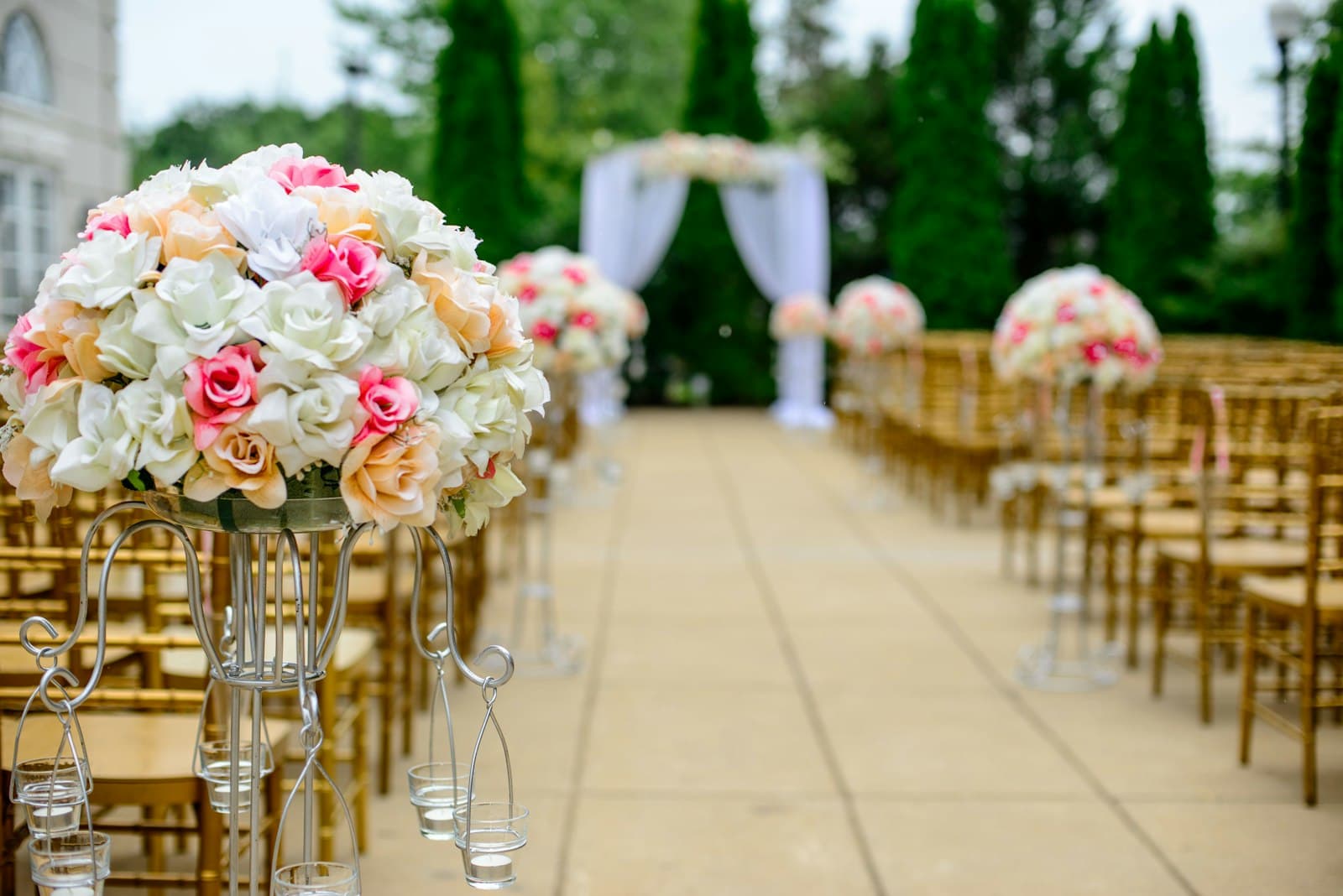 Ceremony aisle lined with rose pillar arrangements