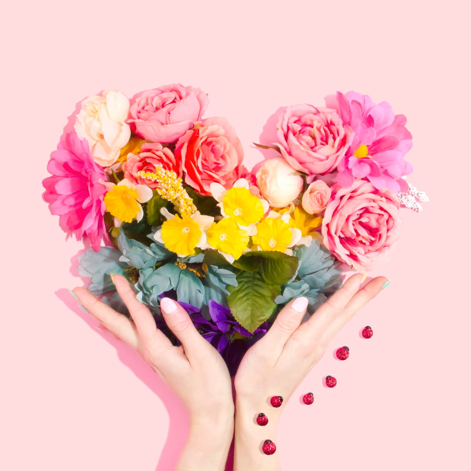 Heart of roses and blooms held in open hands