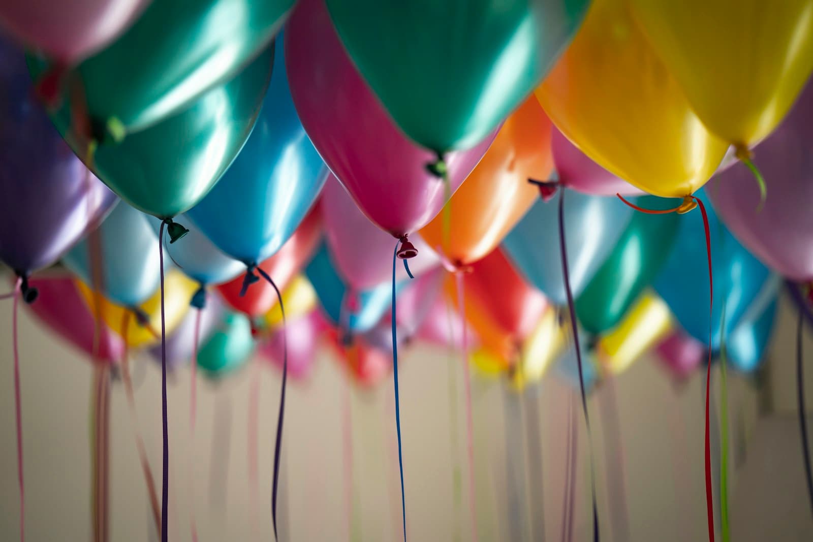 Pastel balloons with ribbons floating at a celebration
